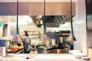 Bilden visar ett restaurangkök med restaurangutrustning. Stekhällar och stekbord används för att skapa effektivare matlagning i restaurangkök och storkök.